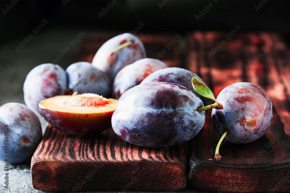 Wall mural fresh plums on dark wooden background closeup