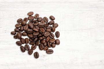 Roasted of coffee beans on white wood background.