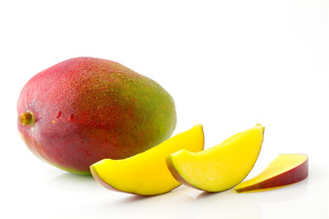 Ripe juicy and appetizing mango fruit and its parts with water drops close-up