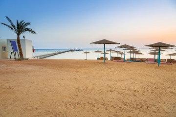 Parasols on the beach of Red Sea in Hurghada at sunrise, Egypt