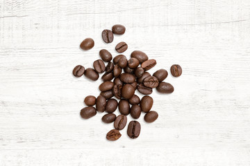 Roasted of coffee beans on white wood background.