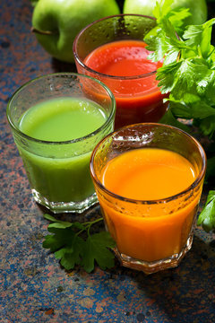 glasses of fresh vegetable juice from carrots, tomatoes and herbs, top view
