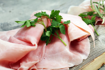 Sliced ham on wooden background. Fresh prosciutto. Pork ham sliced
