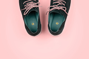 Abstract pastel color Men's shoes with paper pins on pink. Pranks and tricks concept for April...
