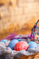 Easter eggs of original color in a wicker basket. Still life of the holiday.