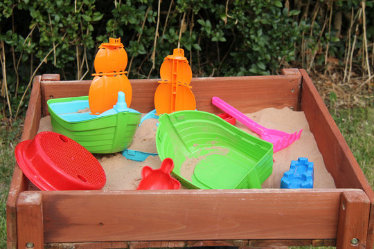 A Collection of Plastic Toys in a Garden Sandpit.