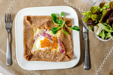 Breton crepe with egg in white plate