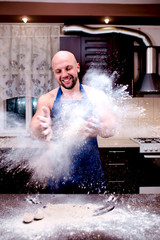 Fototapeta na wymiar A young man chefs throw flour