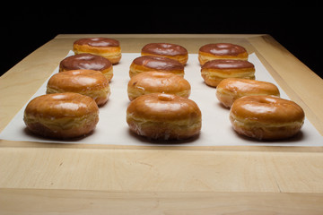 fresh glazed donuts on a cookie sheet