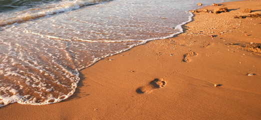 A step walk on sand under the sun light beside the beach
