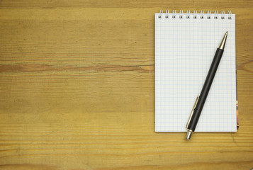 Pen and Notepad on the wooden desk