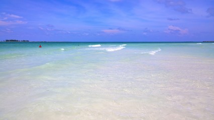 Ocean view of blue sky, beautiful clouds and pacific crystal turquoise water beside a tropical island with powdery white sand .  Cayo Guilermo , Cuba 