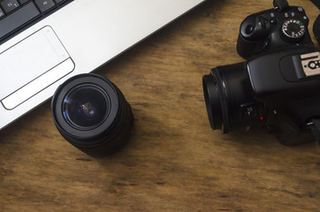 creative environment with a laptop, camera on a wooden table
