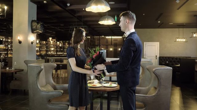 Pair of lovers. The young man and woman meeting in a restaurant for dinner. 4K