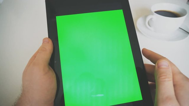 Hand holding tablet pc with green screen. Chroma key.