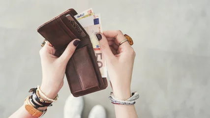 Fotobehang Woman taking out  euro money from her pocket wallet top view © sebra
