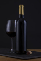 Isolated Red Wine Bottle in a Black, wood Background and no Label
