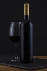 Isolated Red Wine Bottle in a Black, wood Background and no Label