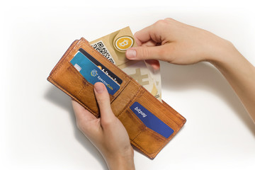 Portafoglio aperto con bitcoin cartacei e carte di credito virtuali, sfondo bianco