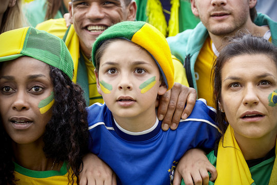 Brazilian football supporters watching match attentively