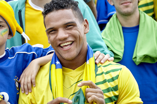 Brazilian football fan smiling cheerfully at match