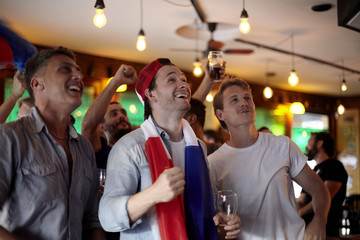 French football fans watching match in bar