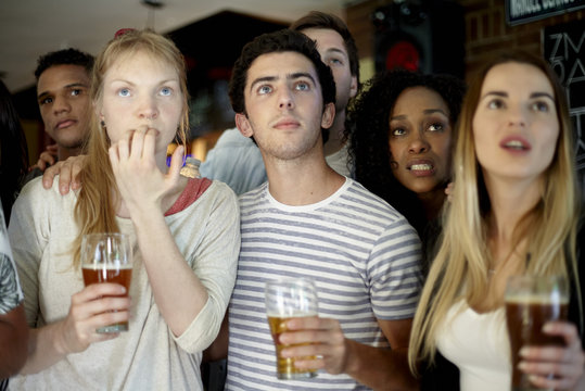 Soccer fans watching soccer match together at a pub