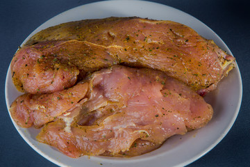 big piece of raw turkey fillet on white plate