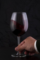 Hand with a Red Wine Glass in Motion