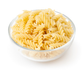 Uncooked fusilli pasta in glass bowl isolated on white background