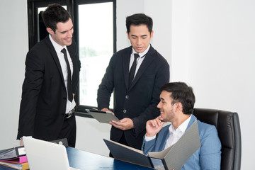 Two businessmen reviewing report in file and tablat to discuss with team about work. Strategy, business, explaining, brainstorming, presentation