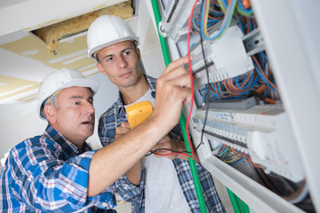 tradesmen installing a distribution board