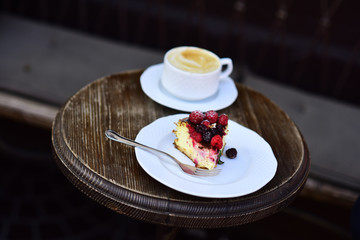 Cheesecake with berries and coffee on wooden table