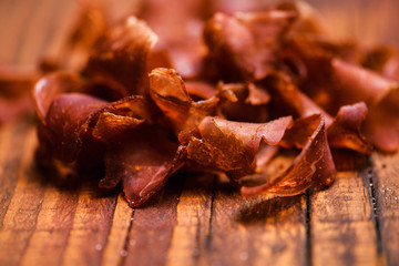 Smoked beef meat slices over rustic background