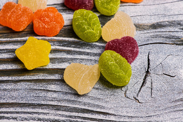 Tasty jelly candies on wooden background