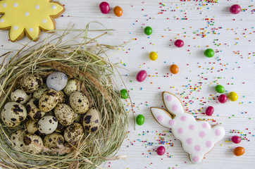 Easter bunny Easter bunny and cookies in the form of the sun. Nest with quail eggs, on a white...