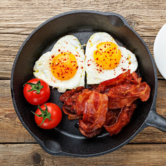 English breakfast - fried egg,tomatoes and bacon.top view