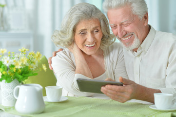 happy beautiful senior couple using tablet 