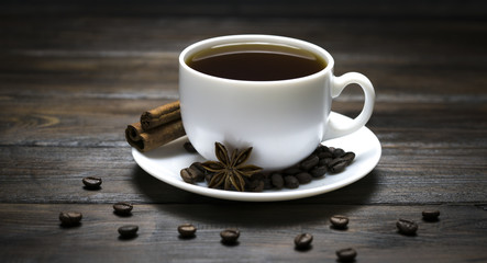 cup of coffee with grains on a wooden background