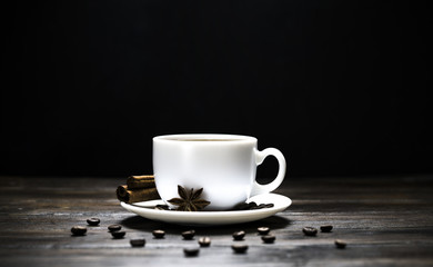 cup of coffee with grains on a wooden background
