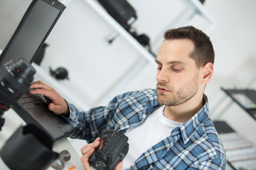 photographer checking photos in camera at desk in office