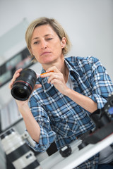 female photographer cleaning the camera lens