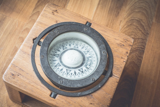 The vintage compass on the wood table.