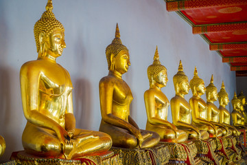 Indoor view of nice Gold Buddha Statues in a row in Wat Pho Temple in Thailand