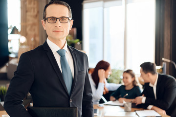 Confident adult man in suit stands in front of office of family lawyer.