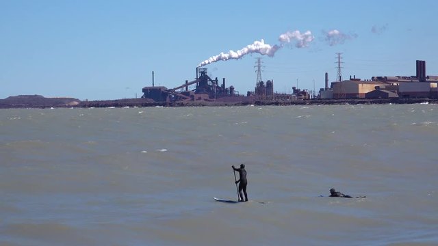 Surfers brave a highly polluted industrial area on Lake Michigan near Gary, Indiana.