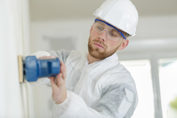 male construction worker smoothing wall surface