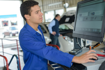 mechanic checking modern electronic diagnostic table