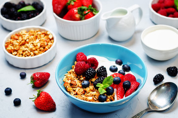 Healthy breakfast with granola, greek yogurt, berries and milk
