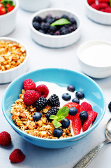 Healthy breakfast with granola, greek yogurt, berries and milk